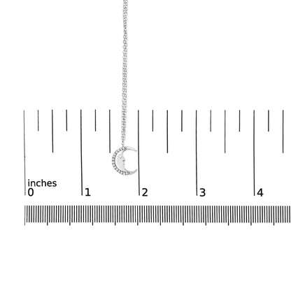 White metal necklace with crescent moon pendant featuring round white gemstones in prong settings, shown hanging against a ruler for size reference, front angle.