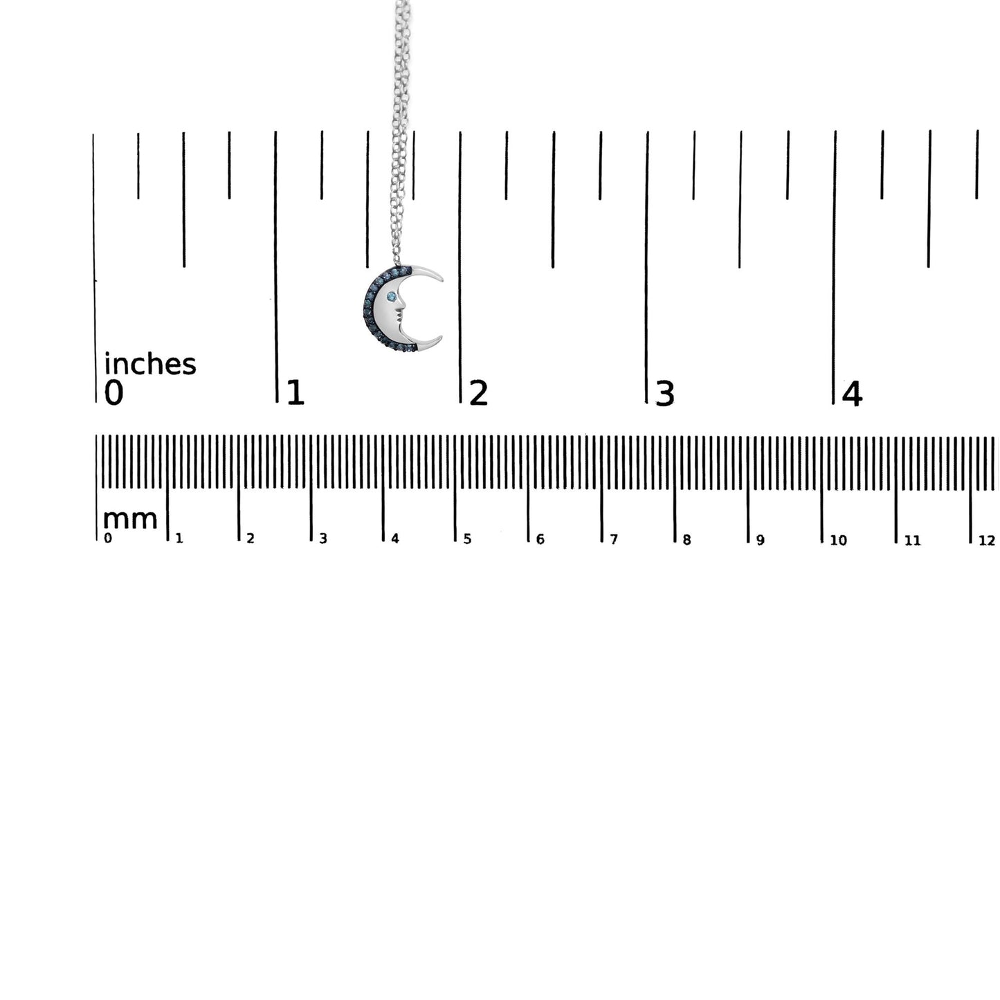 White metal crescent moon necklace with blue round gemstones in prong setting, shown hanging against a ruler for size reference, front angle.