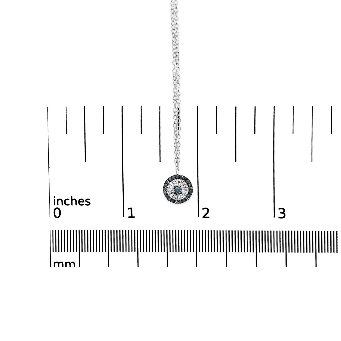 Close-up of a white necklace pendant with a central blue gemstone surrounded by smaller blue gemstones, displayed on a ruler for size reference.