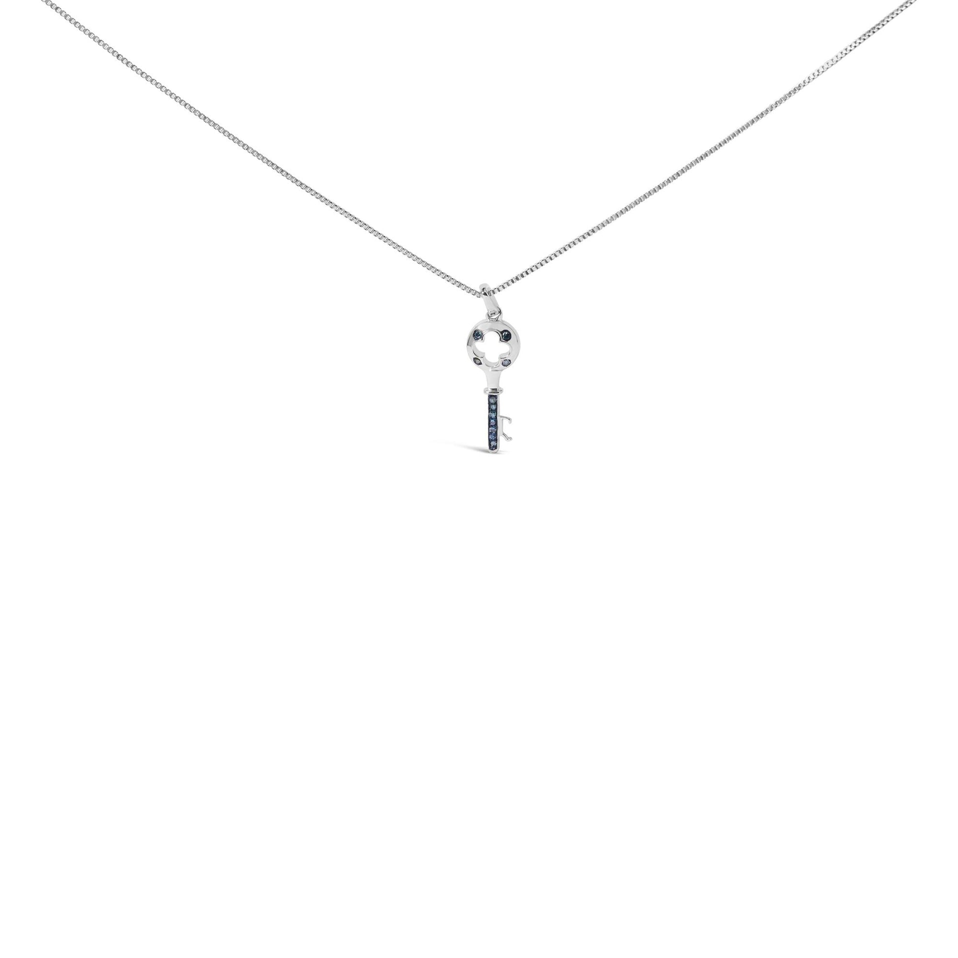 Front-facing shot of a white metal necklace with a key-shaped pendant featuring round blue gemstones in prong settings.