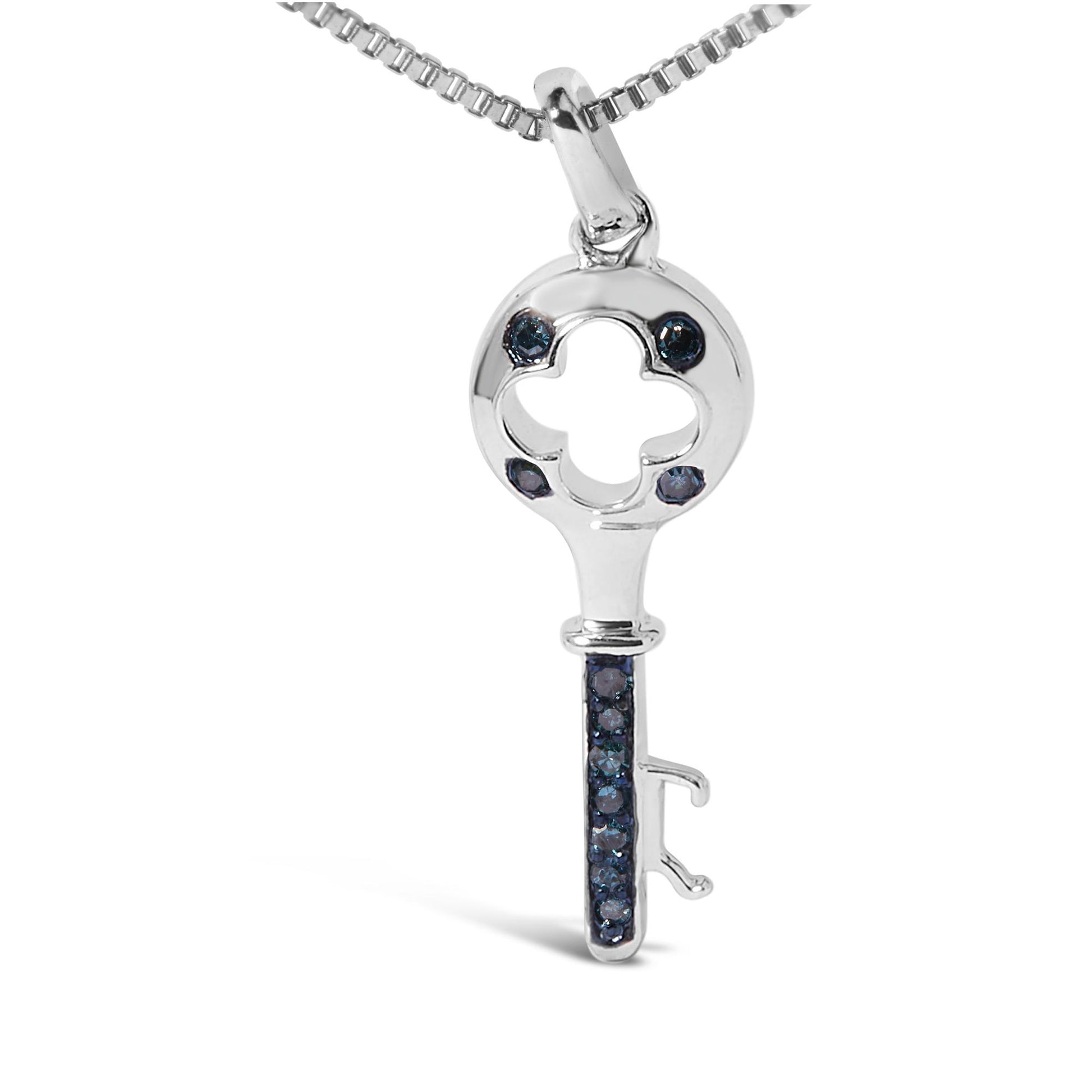 Close-up front view of a white metal key-shaped necklace pendant with round blue gemstones in prong settings, shown hanging from a chain.