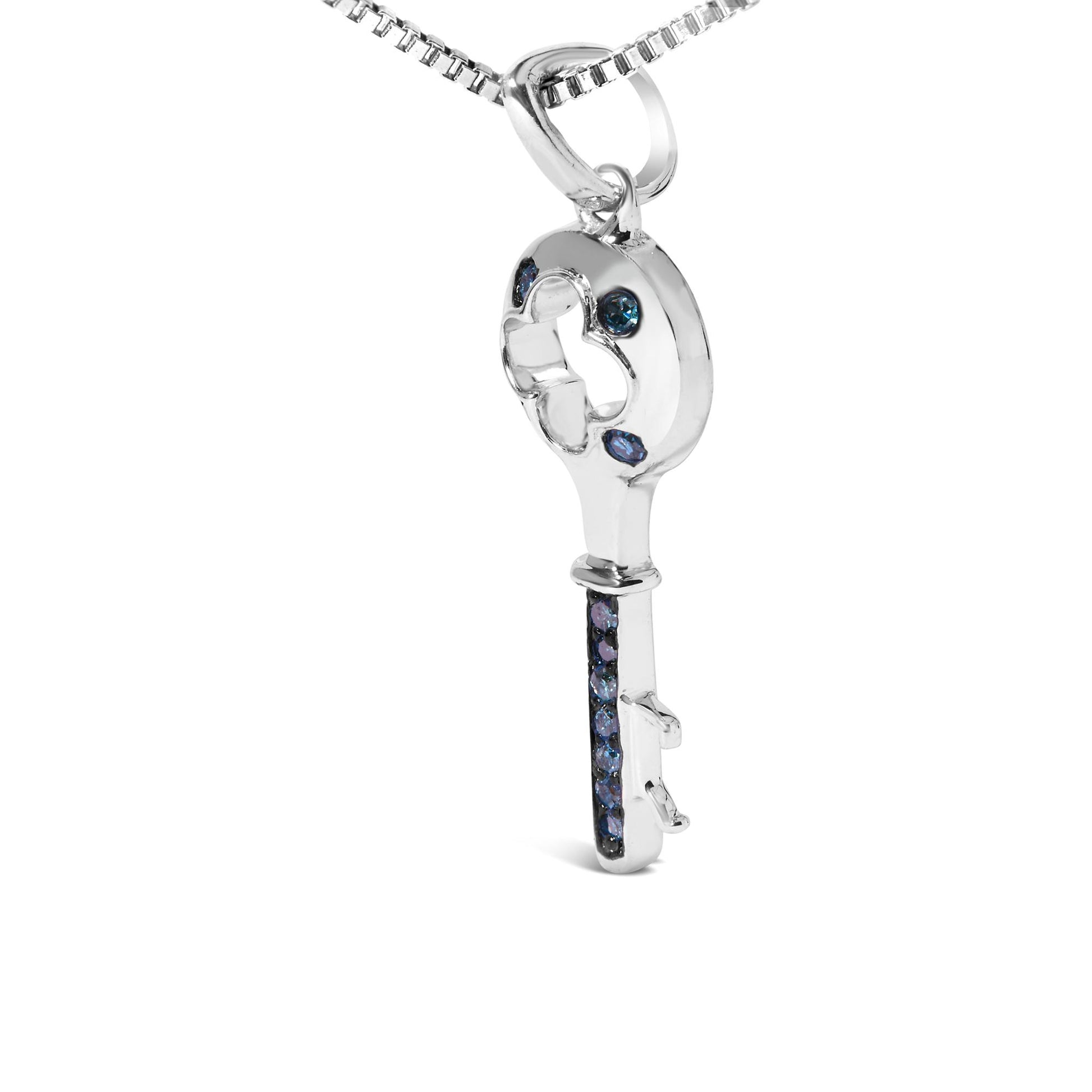 Front angle view of a white metal key-shaped necklace pendant with round blue gemstones set in prongs along the circular top and the shaft of the key.