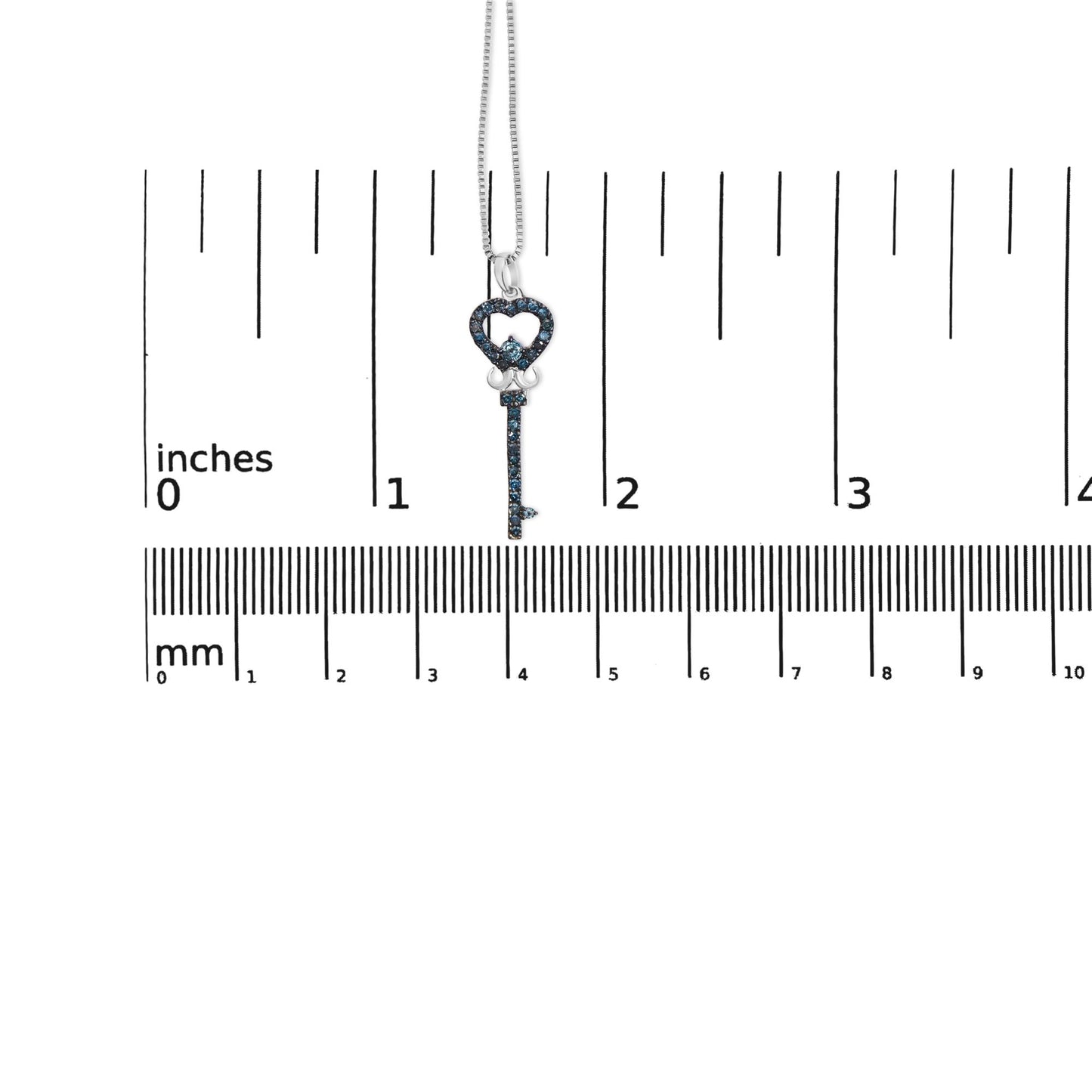 Pendant necklace with a key-shaped charm adorned with round blue gemstones, displayed hanging vertically on a ruler for size reference, front-facing angle.