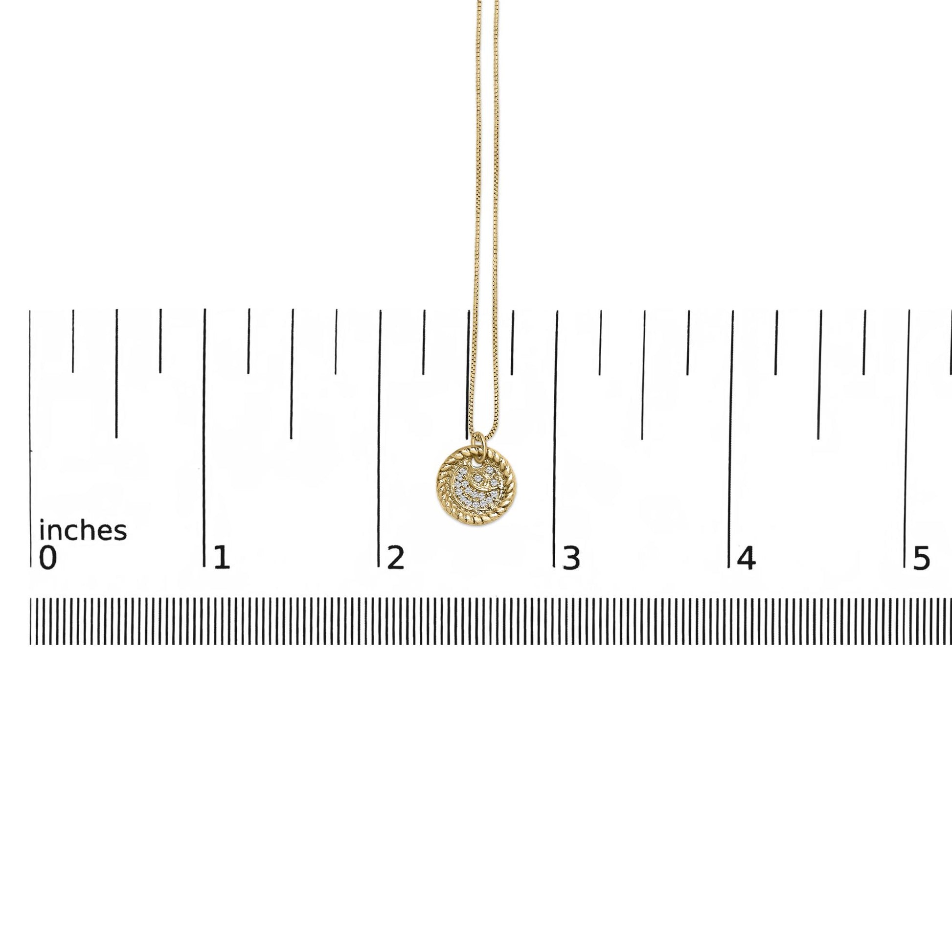 Yellow necklace with a round pendant featuring multiple white round gemstones in a prong setting, shown hanging centered on a measuring scale, front view.
