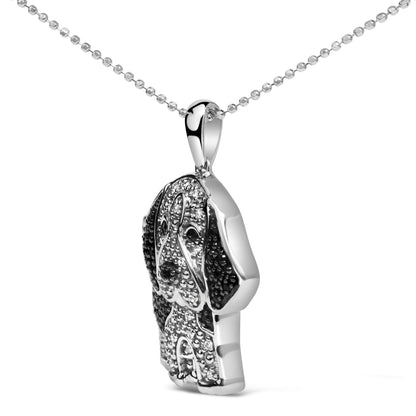 Close-up front angle of a white metal necklace pendant shaped like a dog, decorated with white and black micro-pave set round gemstones.