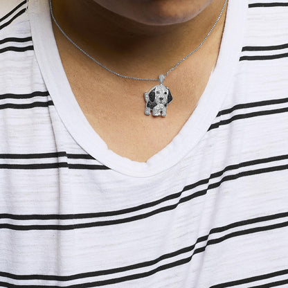 Close-up front view of a white metal necklace on a model, featuring a pendant shaped like a dog with white and black gemstones in a micro-pave setting.