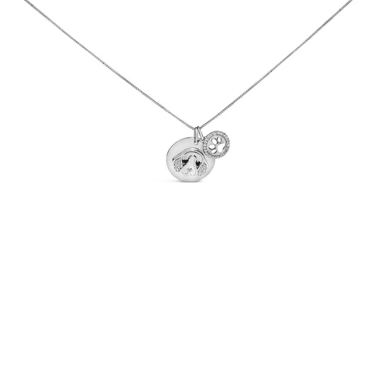 Front angle view of a white metal necklace with two round pendants, one featuring a dog face design with white micro-pave and shared prong set white gemstones, and the other with a paw print surrounded by white micro-pave and bezel set black gemstones.