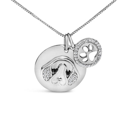 Front view of white metal necklace with two round pendants, one featuring a dog face with white and black gemstones and the other a paw cutout surrounded by white gemstones.