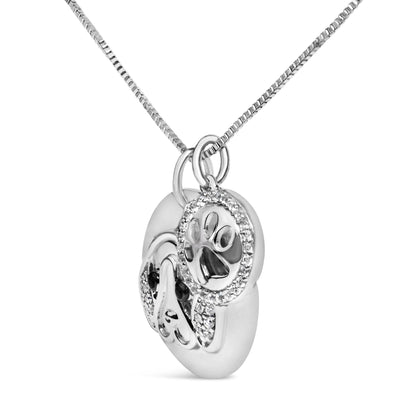Close-up angled view of a white metal dog face pendant necklace with white and black round gemstones in micro-pave, shared prong, and bezel settings.