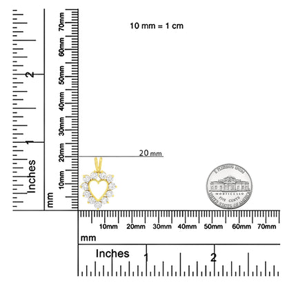 Yellow metal heart-shaped necklace pendant with round brownish gemstones surrounding the heart, shown on a ruler and scale for size reference, front-facing angle.
