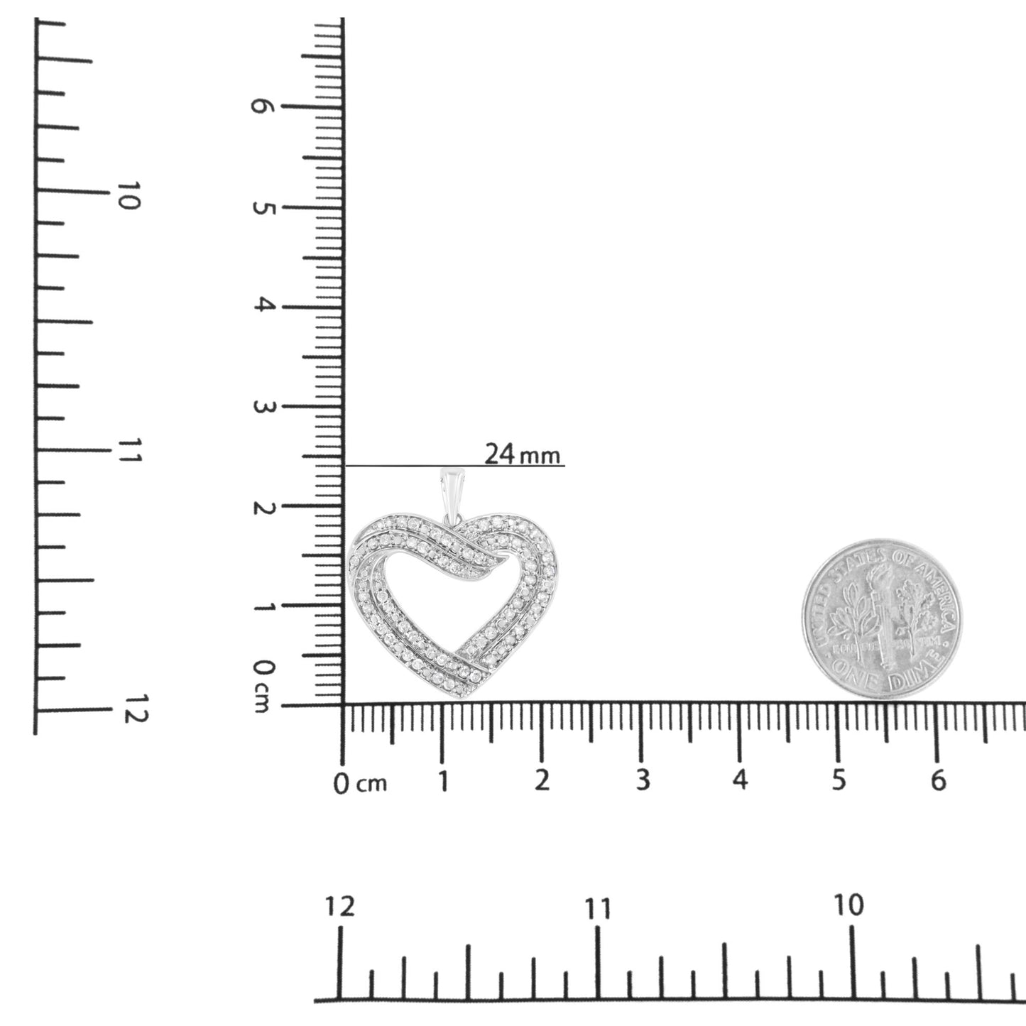 Close-up front view of a white metal heart-shaped necklace pendant with round white gemstones in prong setting, shown on a ruler and next to a dime for size reference.