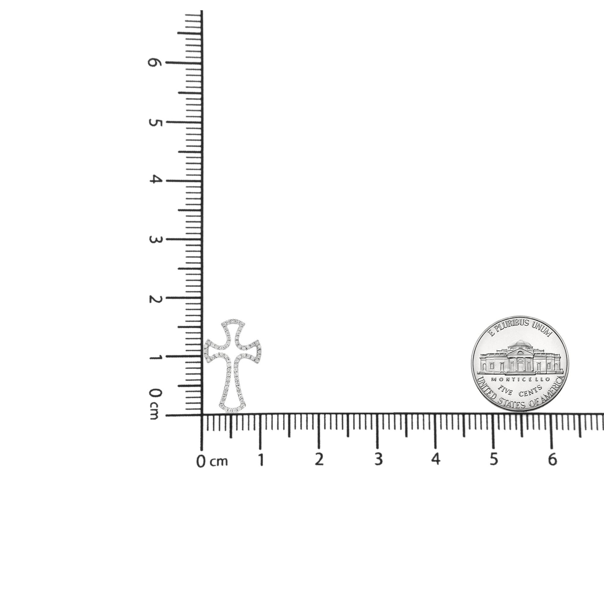 White metal cross-shaped necklace pendant with round white gemstones in prong settings, shown flat on a ruler and scale for size reference, front-facing angle.