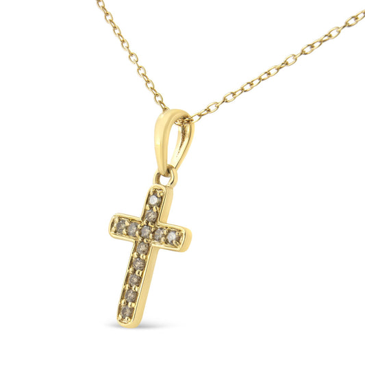 Close-up front angle of a yellow metal cross-shaped pendant necklace accented with round prong-set brownish gemstones.