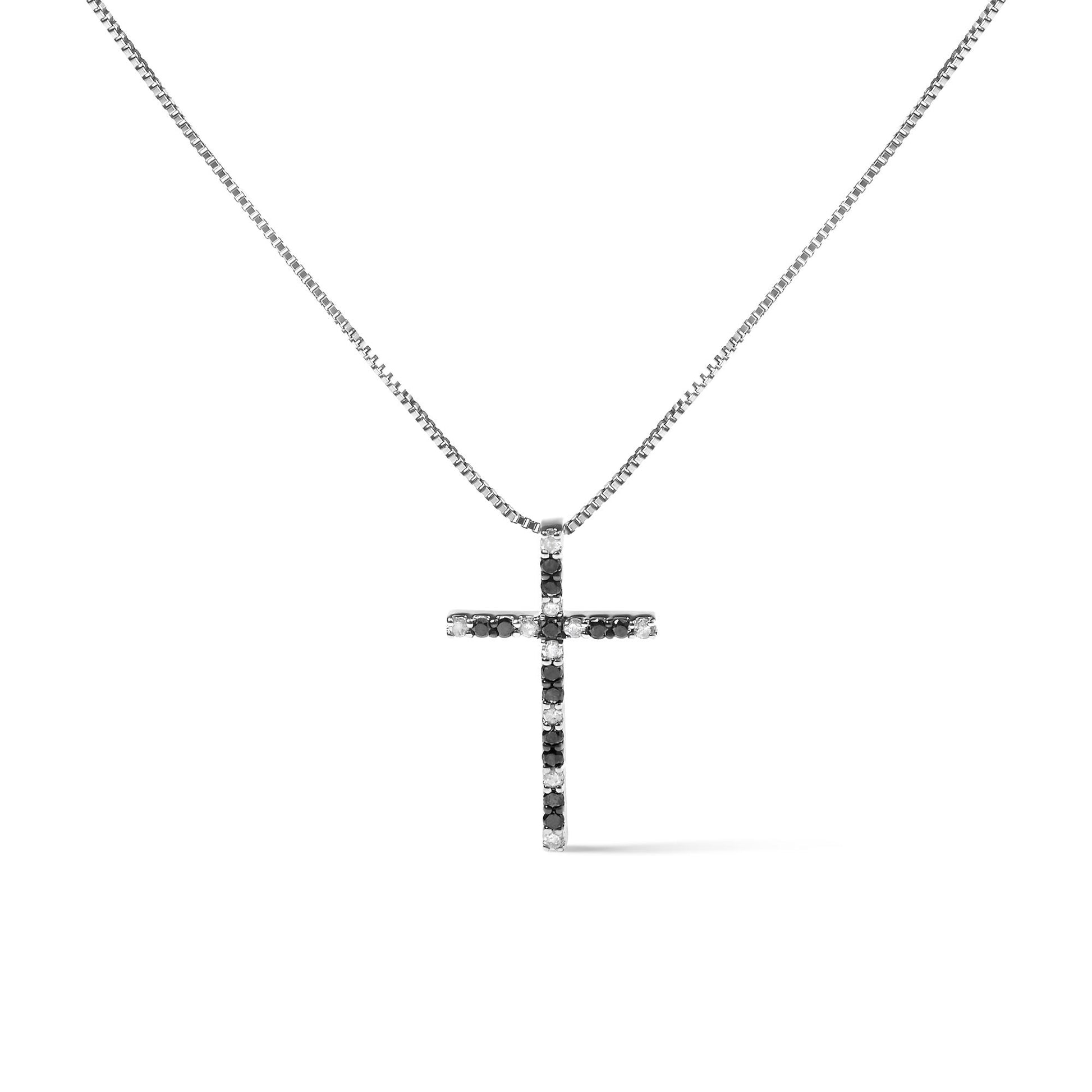 Front view of a white metal necklace with a cross-shaped pendant featuring alternating black and white round gemstones in prong settings.