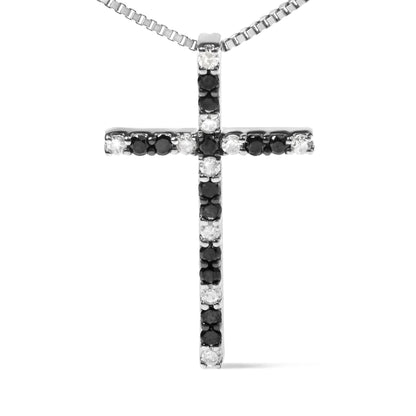 Front-facing shot of a white metal cross necklace pendant set with alternating black and white round prong-set gemstones.