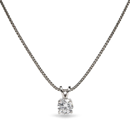 Close-up front view of a white metal necklace with a round white gemstone in a four-prong setting pendant on a chain.