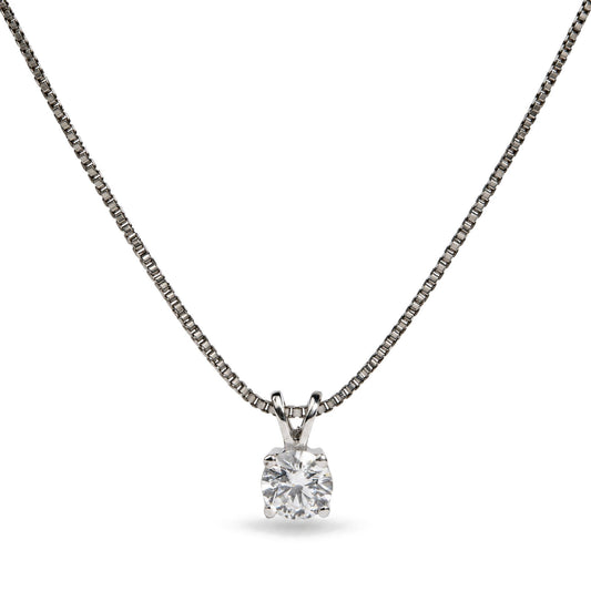 Close-up front view of a white metal necklace with a round white gemstone in a four-prong setting pendant on a chain.