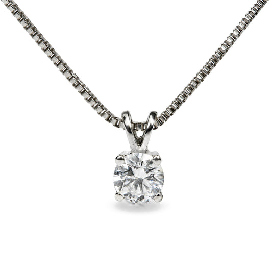 Close-up front view of a white metal necklace with a pendant featuring a single round white gemstone in a four-prong setting.
