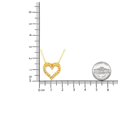 Yellow metal heart-shaped necklace with brownish round gemstones in prong settings, shown flat with ruler and coin for size reference.