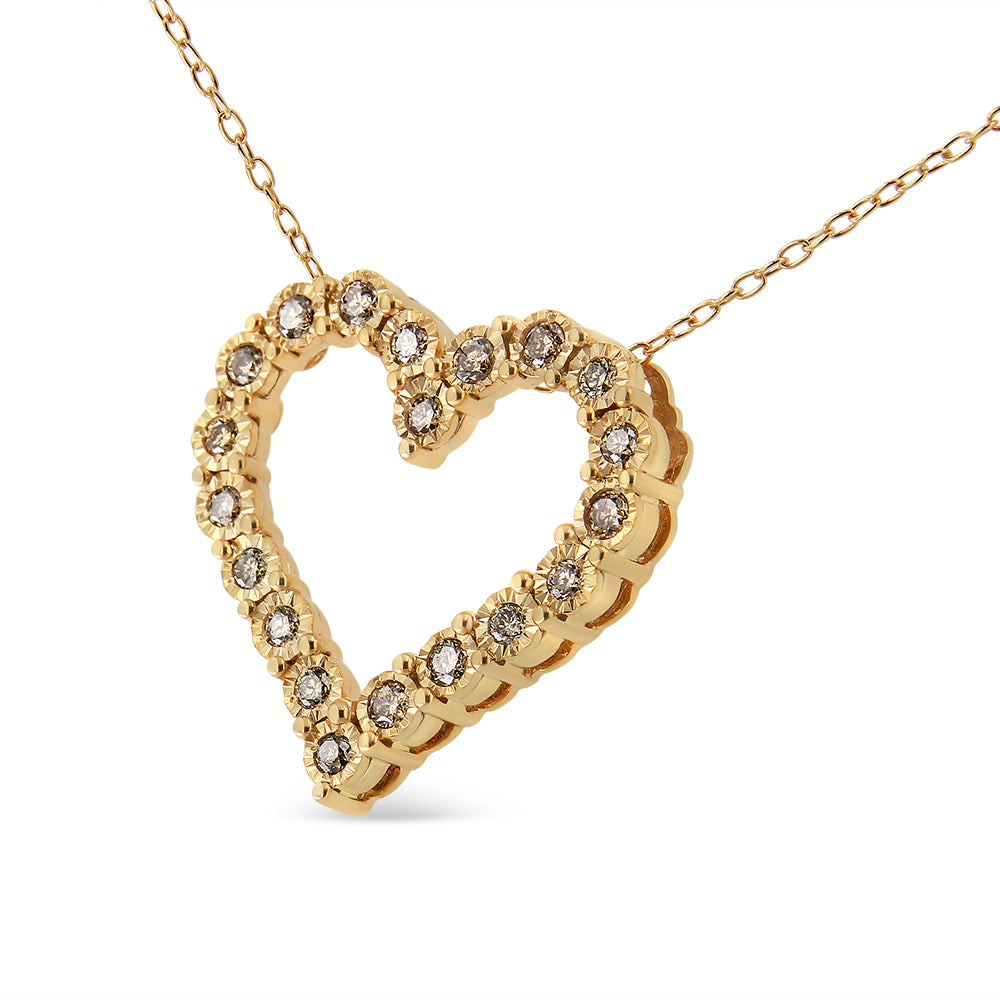 Yellow metal heart-shaped necklace pendant with round brownish gemstones in a miracle setting, shown in a close-up angled view.