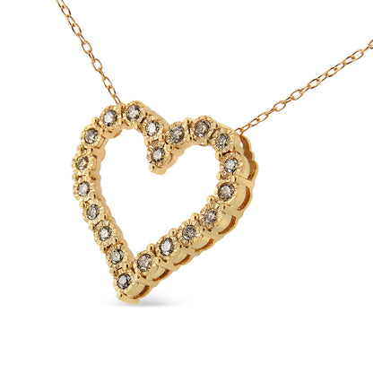 Yellow metal heart-shaped necklace pendant with round brownish gemstones in a miracle setting, shown in a close-up angled view.