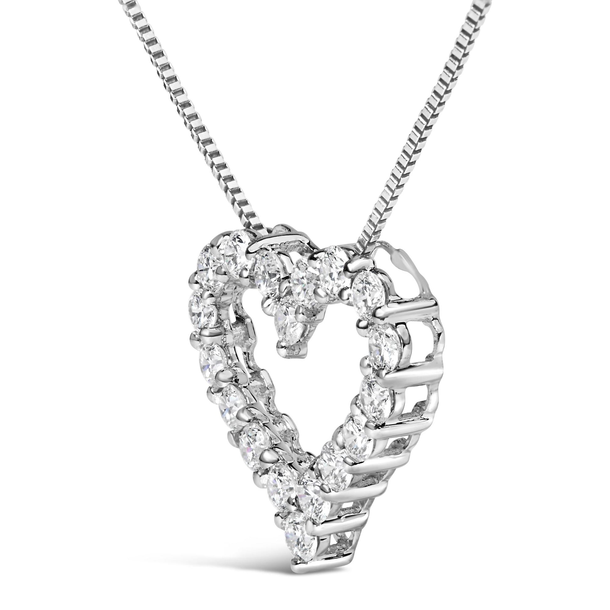 Close-up front angle of a white metal heart-shaped necklace pendant with multiple round white gemstones in prong settings along the heart outline.