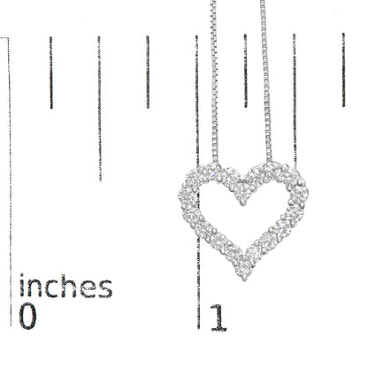 Close-up of a white metal heart-shaped necklace pendant with round white gemstones in prong settings, shown hanging against a ruler for size reference.