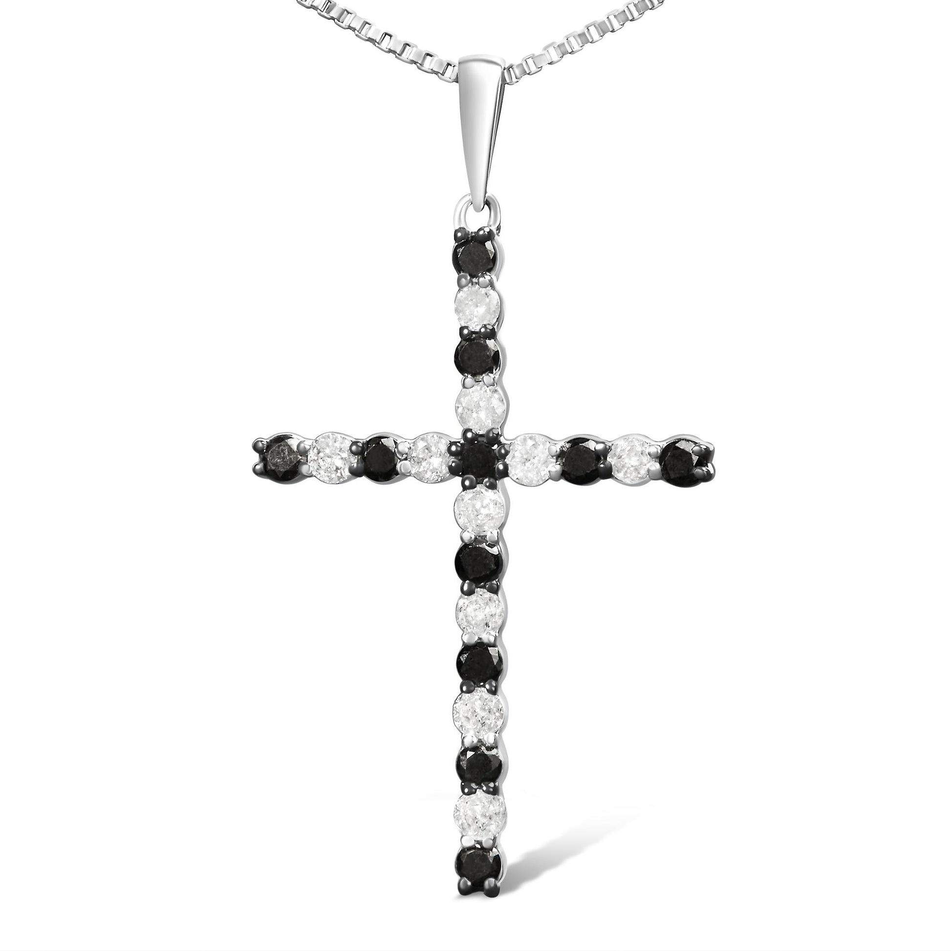 Front-facing image of a white metal cross necklace pendant set with alternating round white and black gemstones in prong settings.