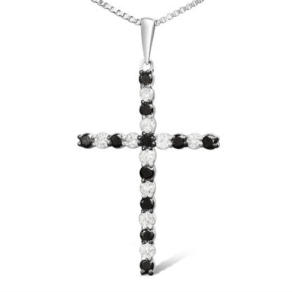 Front-facing image of a white metal cross necklace pendant set with alternating round white and black gemstones in prong settings.