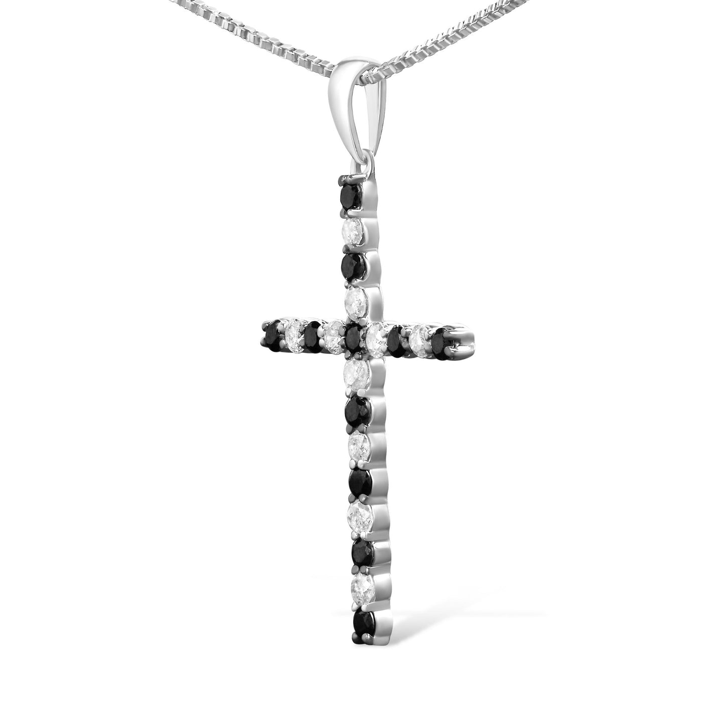 Close-up front angle of a white metal cross-shaped necklace pendant with alternating black and white round prong-set gemstones.