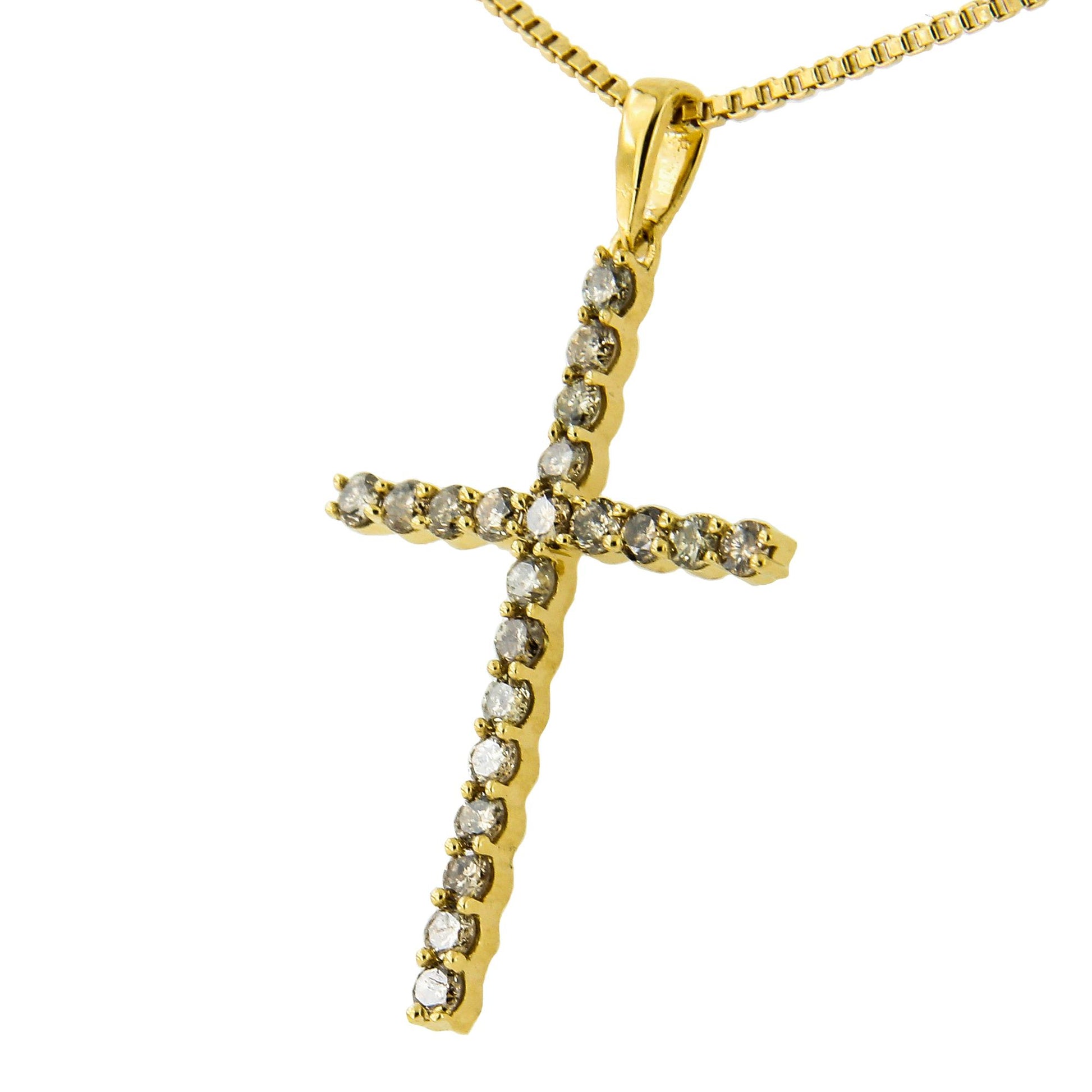 Close-up front angle of a yellow metal cross-shaped necklace pendant with round prong-set brownish gemstones.