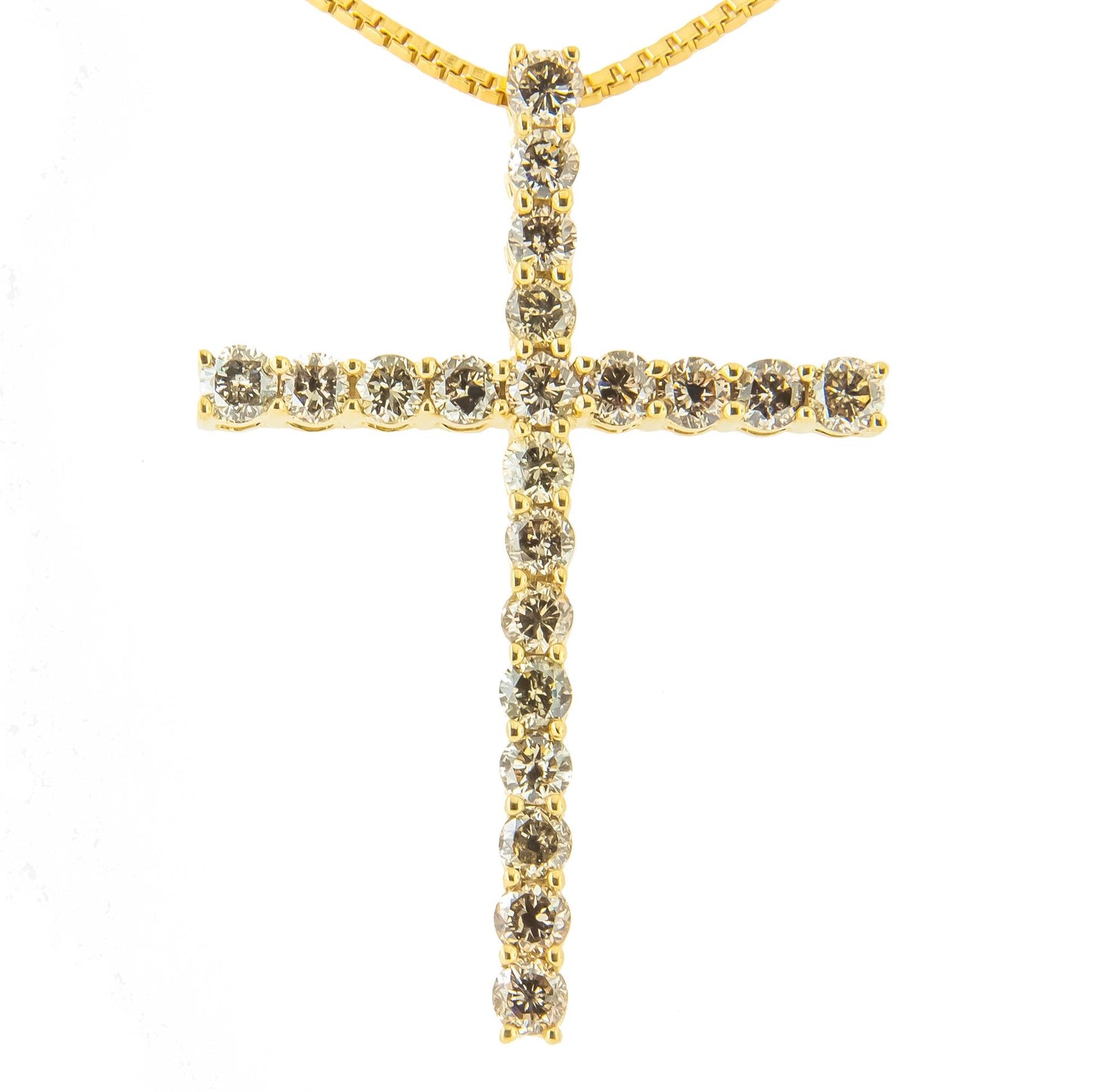 Close-up front view of a yellow metal cross necklace pendant with round brownish prong-set gemstones.