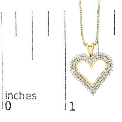 Yellow metal heart-shaped necklace pendant with two rows of small white gemstones in prong settings, hanging on a chain, photographed on a ruler for size reference in a front view.