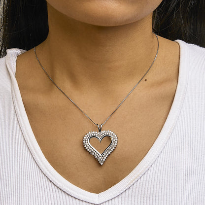 Front view of a white heart-shaped necklace with round white gemstones in prong setting, worn on a model with a white top.