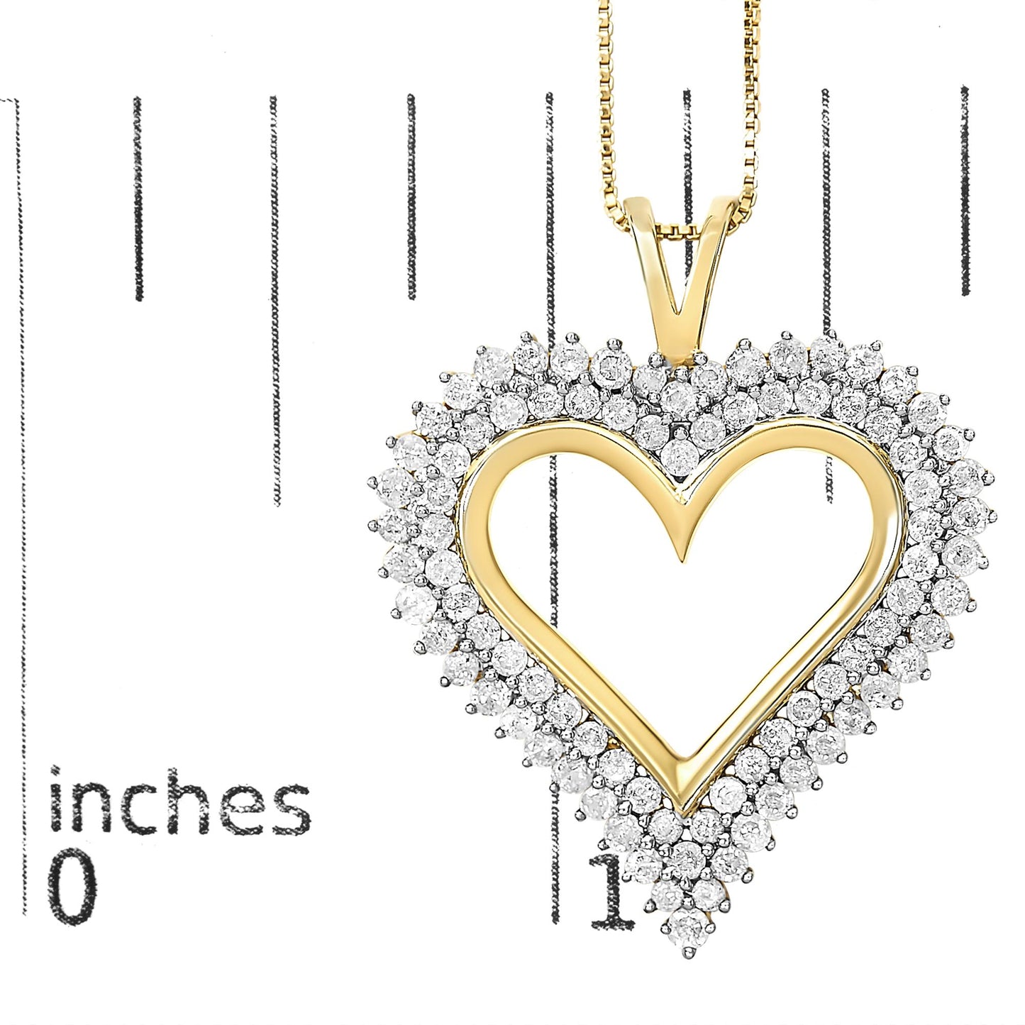 Close-up front view of a yellow metal heart-shaped necklace pendant with white round gemstones in prong settings around the border, shown on a ruler for size reference.