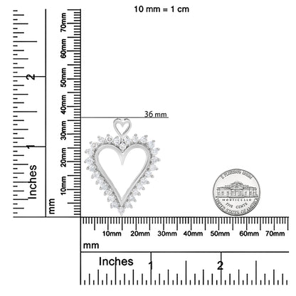 Top-down view of a white metal heart-shaped necklace pendant with a smaller heart at the top, surrounded by round white gemstones in prong settings, placed on a ruler for size reference.