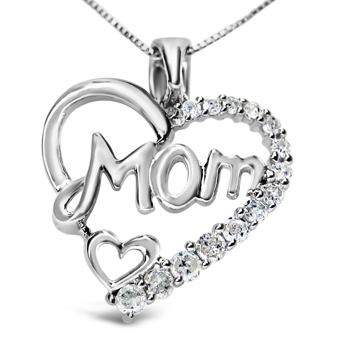 Close-up front angle of a white metal necklace pendant shaped as a heart with the word 'Mom' inside and accented with round white gemstones along one side and a small heart outline at the bottom.