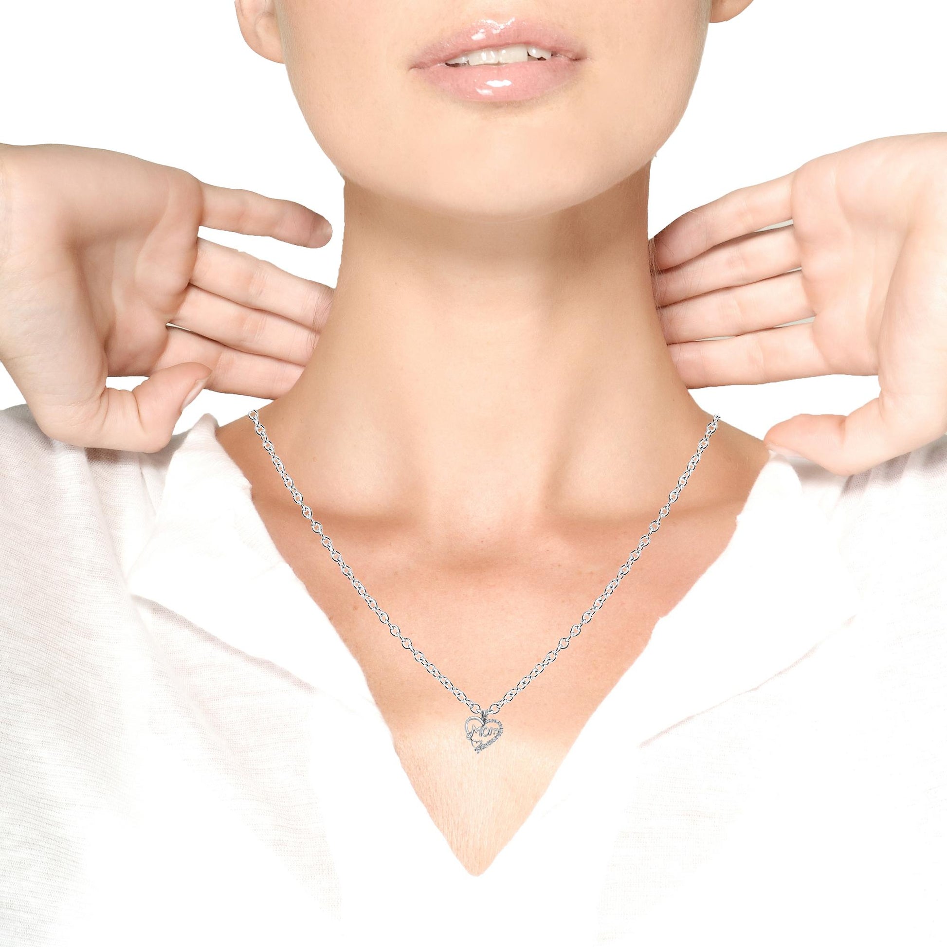 Close-up front view of a model wearing a white metal necklace with a heart-shaped pendant featuring round white gemstones in prong settings.