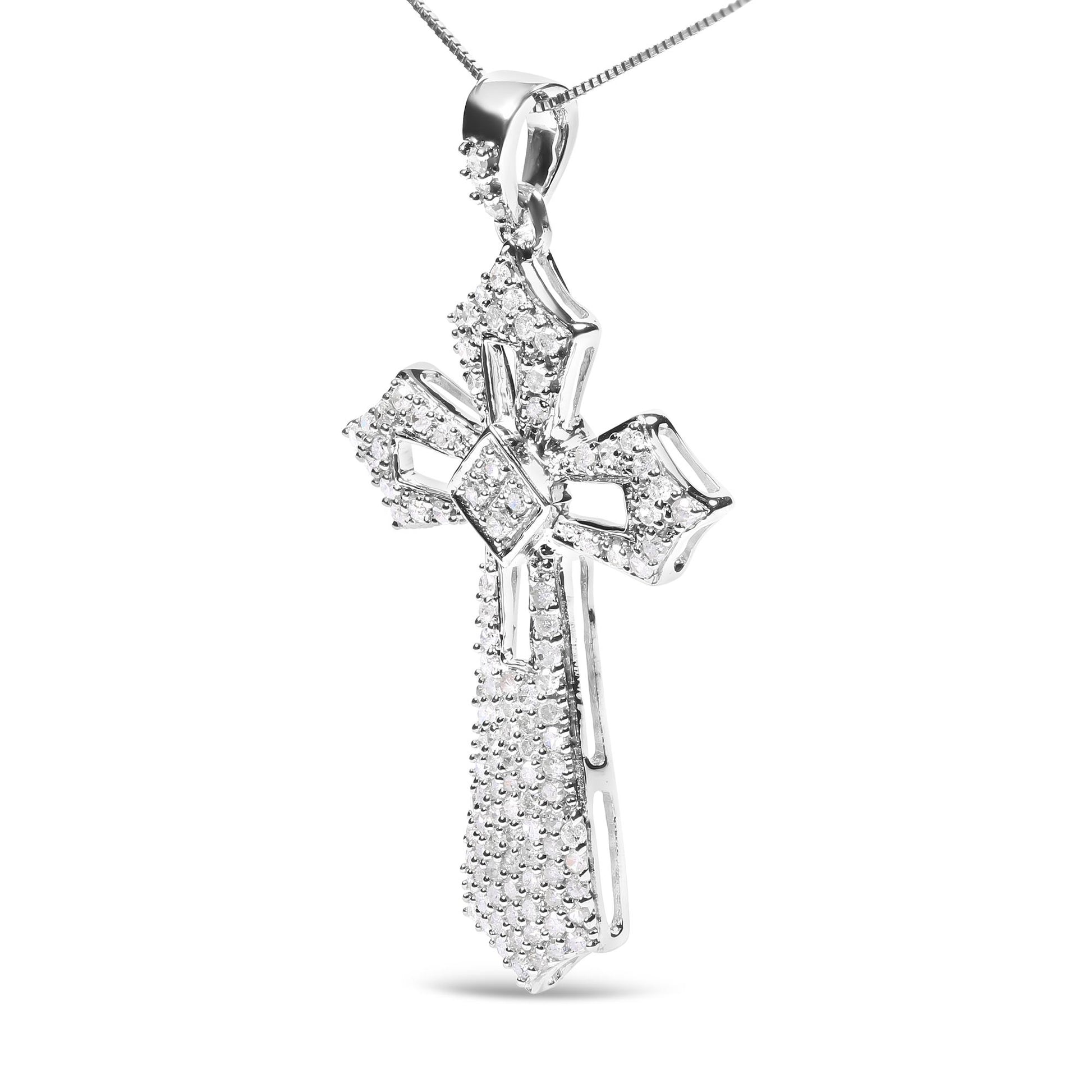 Close-up front-facing shot of a white metal cross-shaped necklace pendant adorned with round white gemstones in prong settings.