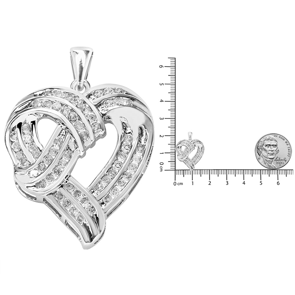 Close-up angled shot of a white metal heart-shaped necklace pendant with intertwined bands set with round white gemstones, shown next to a ruler and coin for size reference.