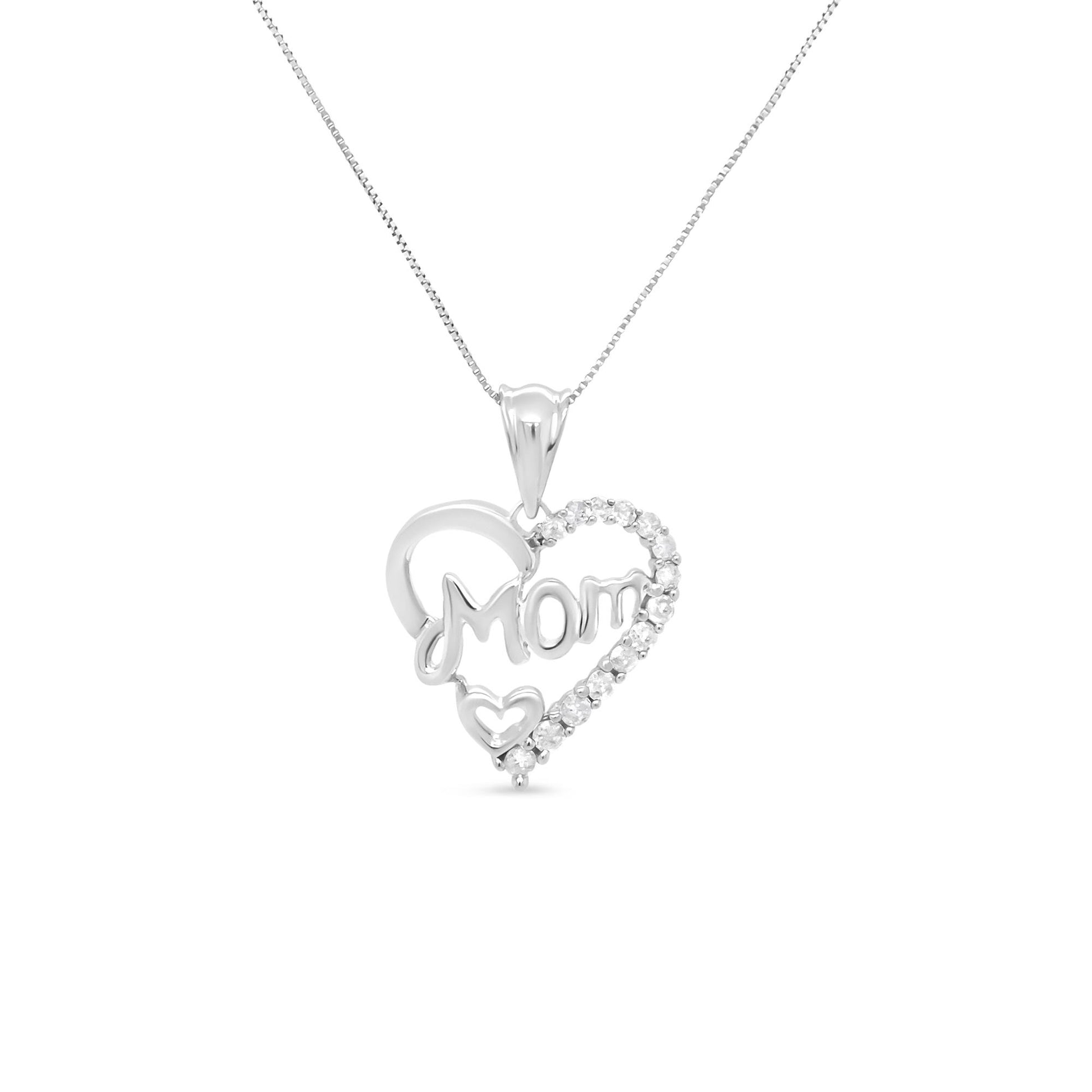 Front view of white metal heart-shaped necklace pendant with the word 'Mom' and small heart detail, adorned with multiple round white gemstones in prong settings.