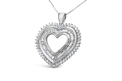 Close-up front angle of a white metal heart-shaped necklace pendant with round prong-set white gemstones on the outer edge and baguette channel-set white gemstones on the inner part of the heart, suspended on a chain.