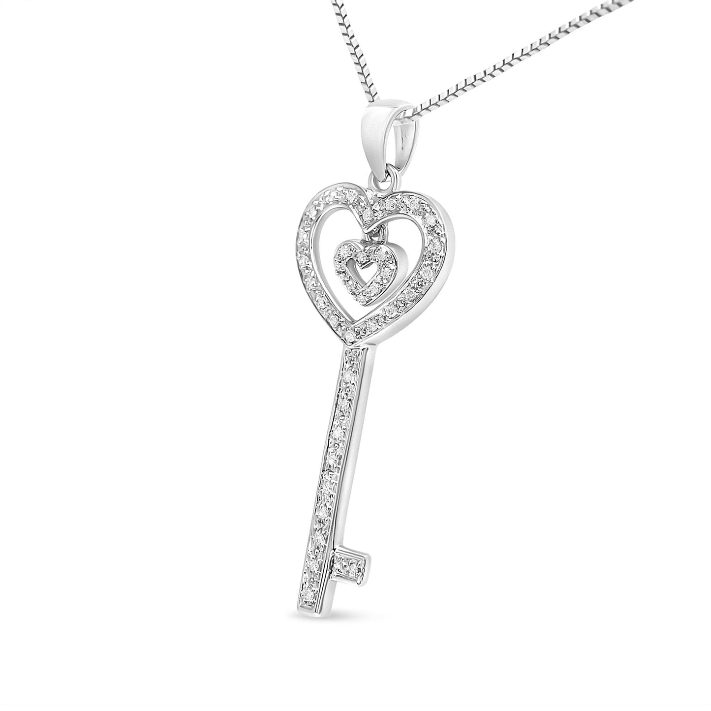 Front angled view of a white metal key-shaped necklace pendant with two heart-shaped outlines encrusted with round white gemstones in prong settings, hanging from a box chain.