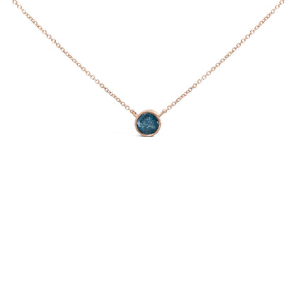 Close-up front view of a rose-colored necklace with a round blue gemstone set in a bezel setting, shown on a white background.