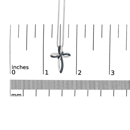 White metal necklace with a cross pendant featuring blue round gemstones in prong settings, hanging against a ruler for size reference, front view.