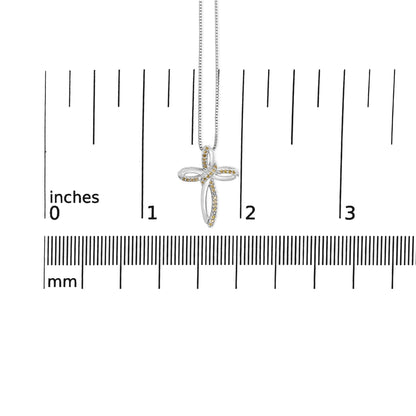 White metal cross-shaped necklace pendant with small yellow gemstones in prong settings, shown front-facing on a ruler for size reference.