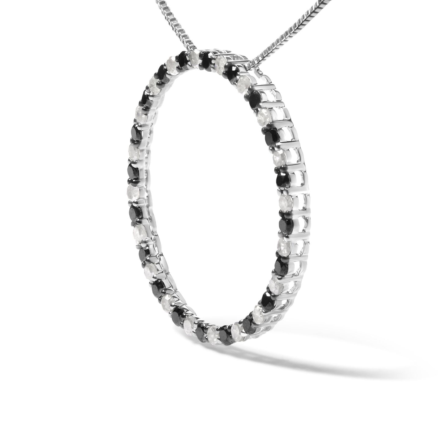Close-up front angled view of a white metal necklace pendant in a circular hoop shape set with alternating round black and white gemstones in prong settings, shown on a chain against a white background.
