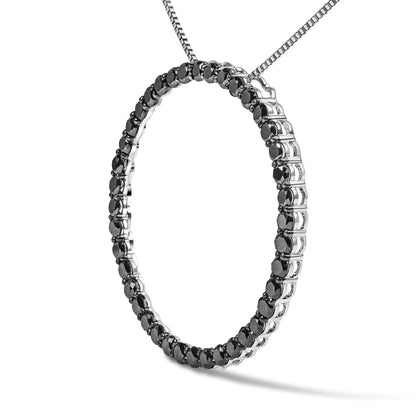 White metal necklace with a circular pendant set with round black gemstones in shared prong settings, shown in a close-up angled view.
