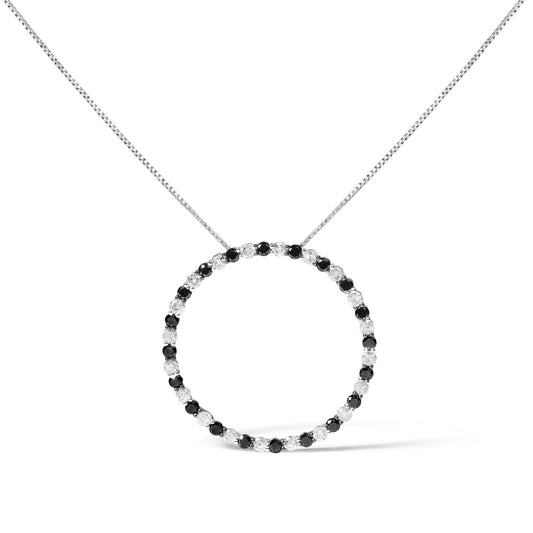 Front angle view of a white metal necklace with a circular pendant featuring alternating round prong-set black and white gemstones.