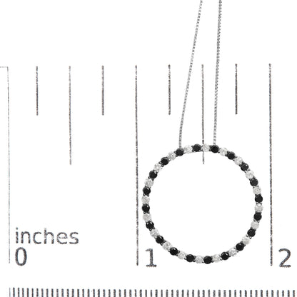 Top-down close-up of a white necklace with alternating black and white round prong-set gemstones forming a circle, shown on a ruler for size reference.